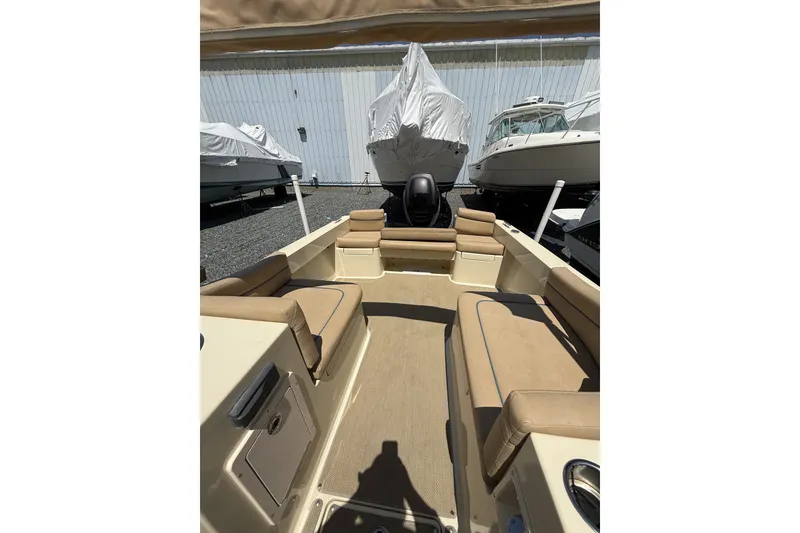 Slide: The Image of 2018 Vanquish Bristol Harbor 23 boat interior with tan seating, docked in storage. - 6
