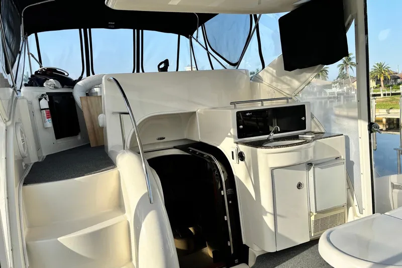 Slide: The Image of 2004 Meridian 459 Motoryacht interior with stairs, kitchenette, and waterfront view. - 23