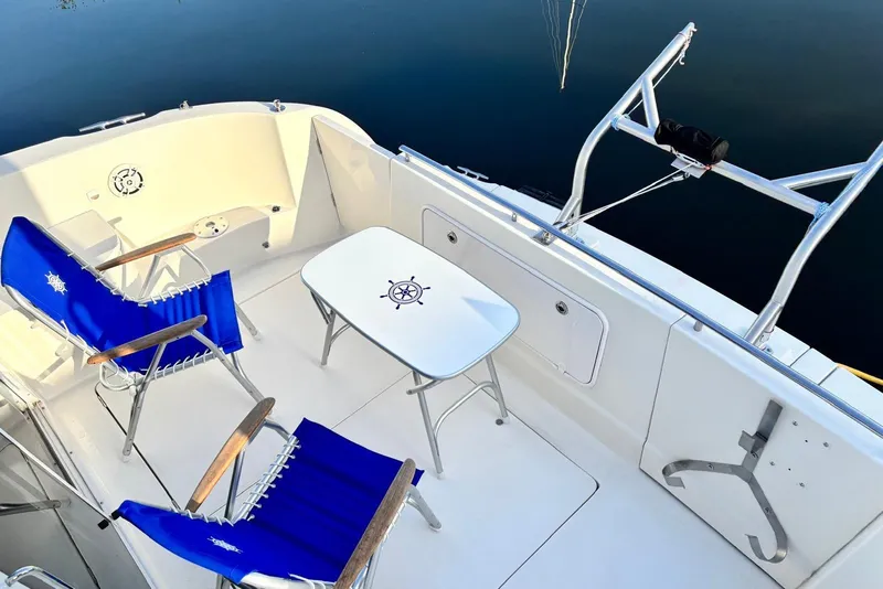 Slide: The Image of 2004 Meridian 459 Motoryacht deck with blue chairs and nautical-themed table. - 12