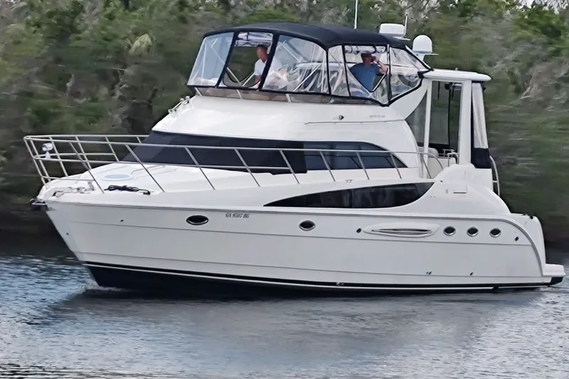 The Image of 2004 Meridian 459 Motoryacht cruising on a calm river with lush greenery. - 0