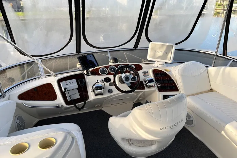 Slide: The Image of 2004 Meridian 459 Motoryacht helm with Garmin navigation and luxurious white seating. - 9