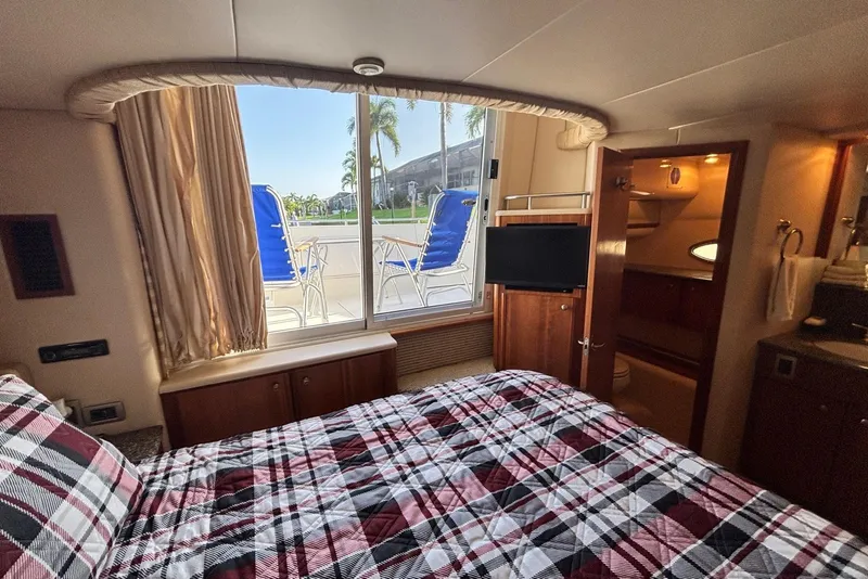 Slide: The Image of Luxurious 2004 Meridian 459 Motoryacht bedroom with plaid bedding and outdoor view. - 27