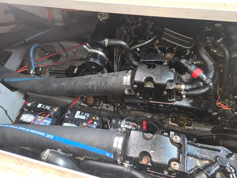 Slide: The Image of The engine compartment of a 1987 Sea Ray 300 Weekender shows two engines with hoses and batteries. - 20