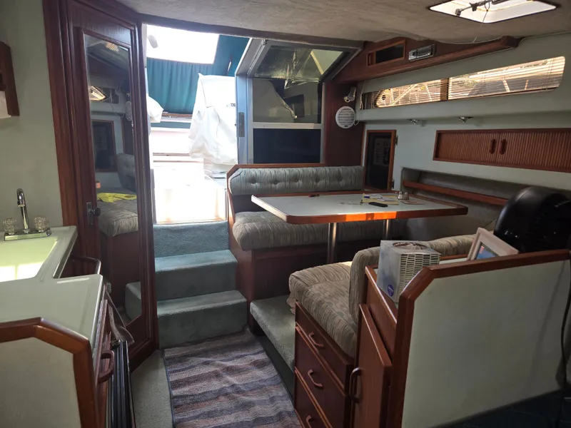 Slide: The Image of Interior of a 1987 Sea Ray 300 Weekender with seating area and kitchenette. - 13