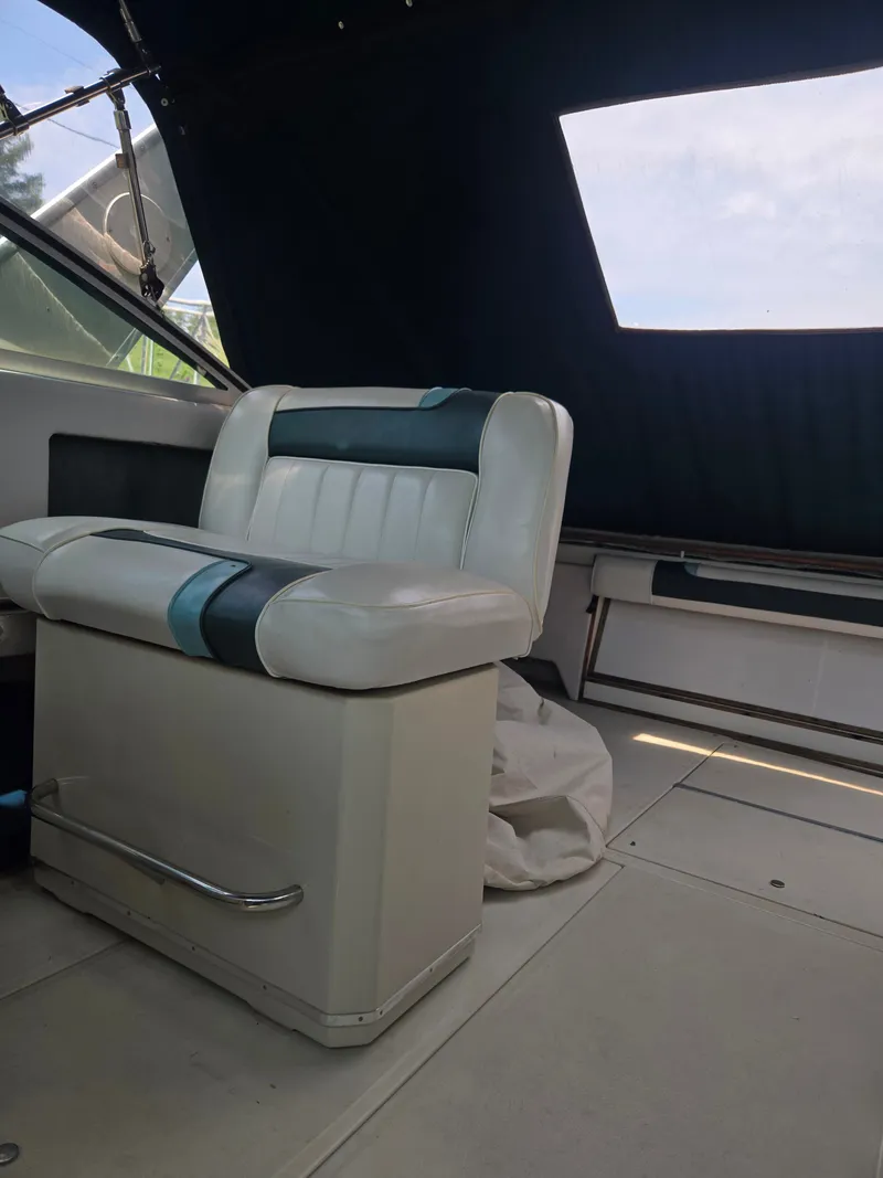 Slide: The Image of Interior of a 1987 Sea Ray 300 Weekender with a white seat and blue accents. - 16