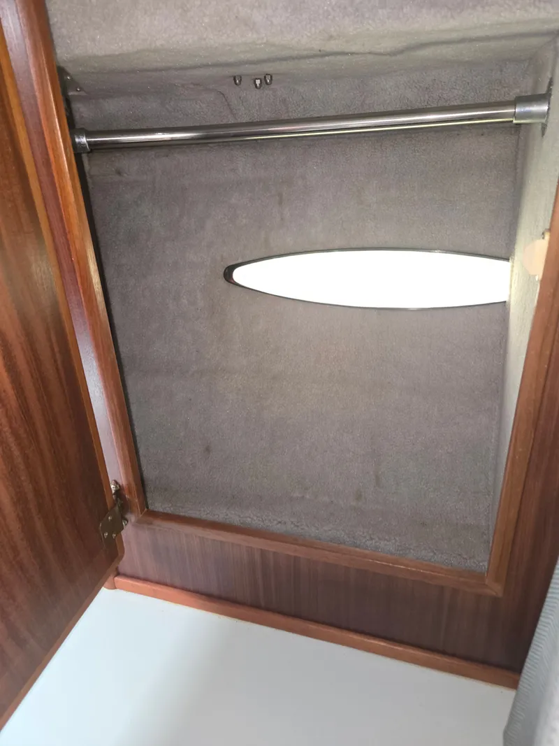 Slide: The Image of A wooden cabinet with a clothes rod and an oval light on the ceiling. - 15