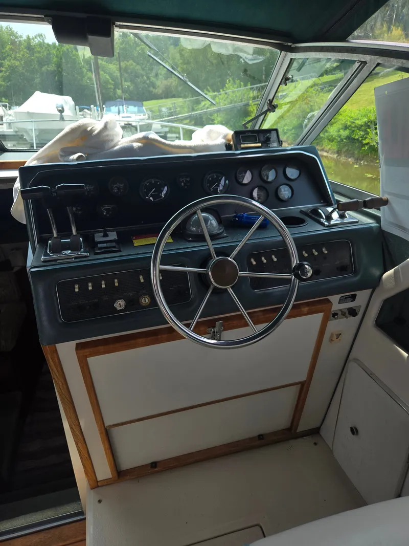 Slide: The Image of The cockpit of a 1987 Sea Ray 300 Weekender with a classic steering wheel and instruments. - 17