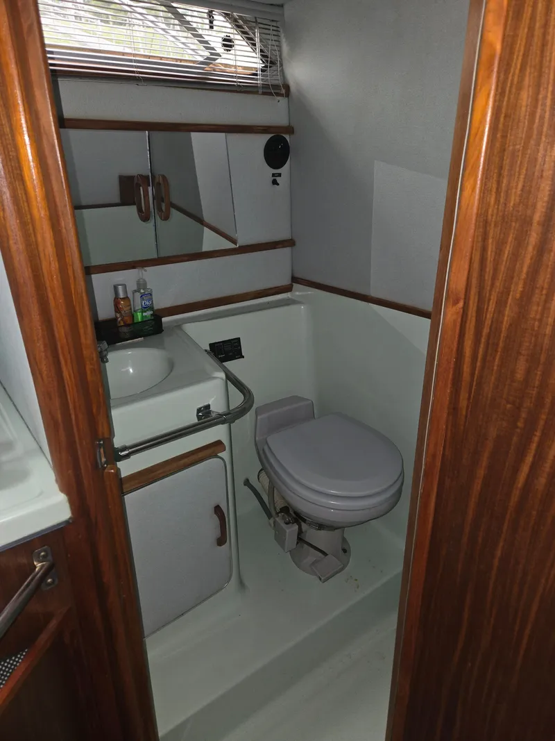Slide: The Image of The image shows the bathroom of a 1987 Sea Ray 300 Weekender with a toilet and sink. - 8
