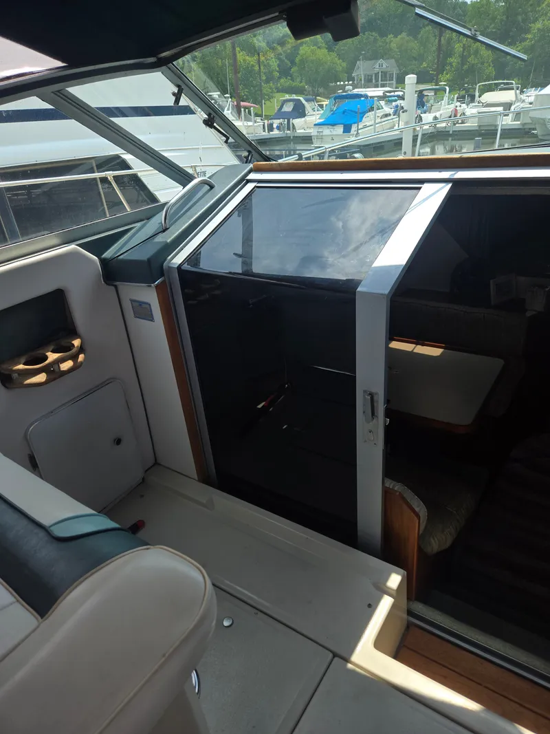 Slide: The Image of The image shows the cockpit of a 1987 Sea Ray 300 Weekender. There's a door leading to the cabin. - 18