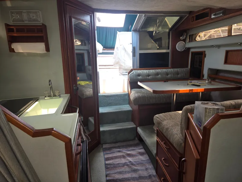 Slide: The Image of Interior of a 1987 Sea Ray 300 Weekender with cozy seating area and kitchenette. - 14
