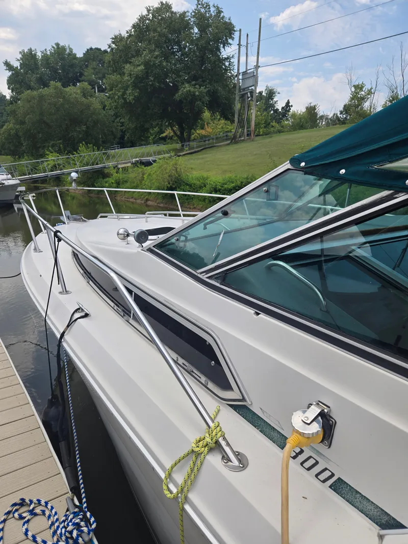 Slide: The Image of A 1987 Sea Ray 300 Weekender docked. It features a green canopy and polished railings. - 4