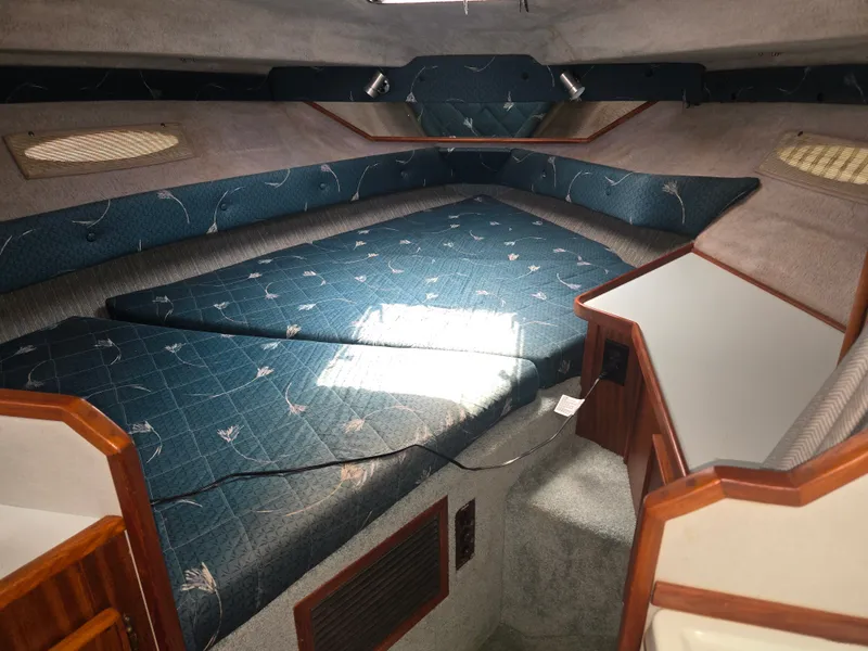 Slide: The Image of Interior of a 1987 Sea Ray 300 Weekender with blue upholstery and wood accents. - 12