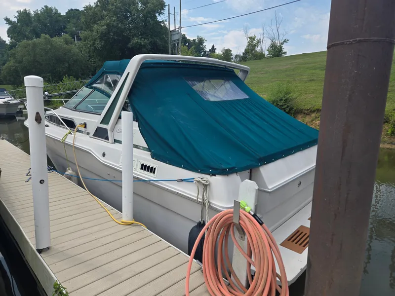 The Image of A 1987 Sea Ray 300 Weekender docked. It features a blue canvas cover. - 0