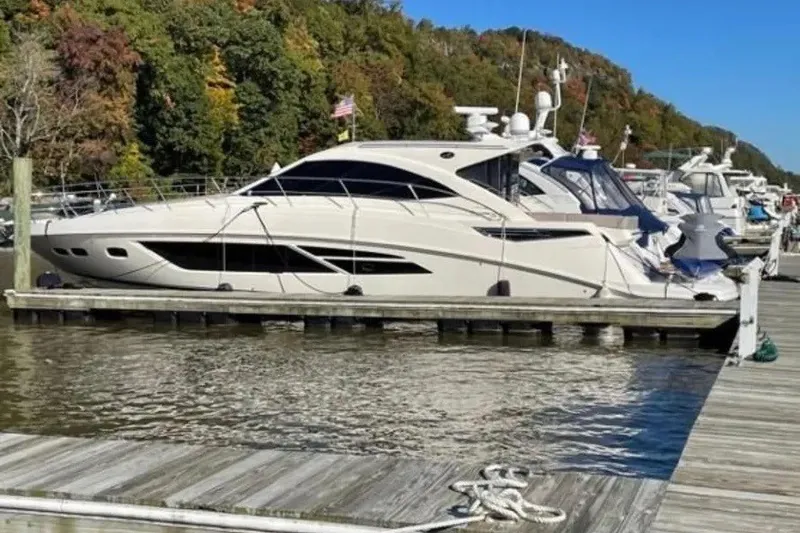 Slide: The Image of 2016 Sea Ray Sundancer 510 yacht docked at a marina with scenic background. - 6