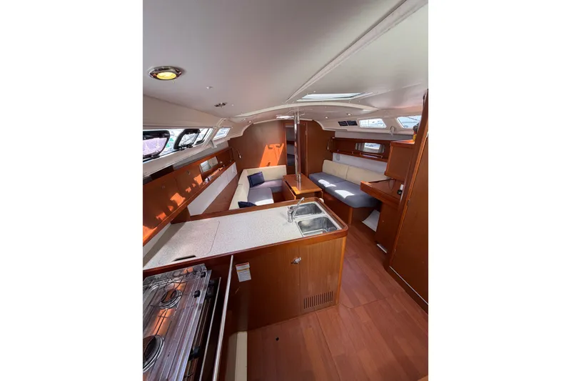 Slide: The Image of Interior of 2013 Beneteau Oceanis 370 yacht, featuring a modern kitchen and cozy seating area. - 12