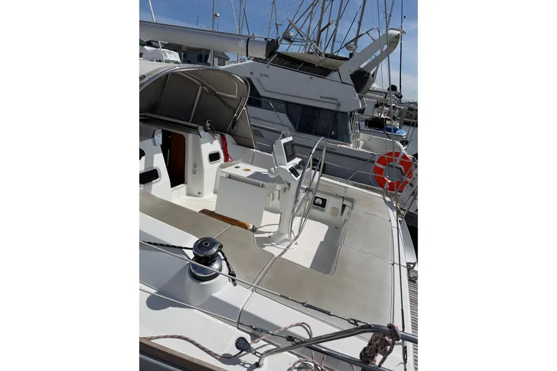Slide: The Image of 2013 Beneteau Oceanis 370 sailboat deck with steering wheel and marina view. - 6