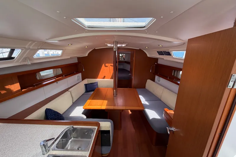 Slide: The Image of Interior of 2013 Beneteau Oceanis 370 yacht with cozy seating and wooden finishes. - 13