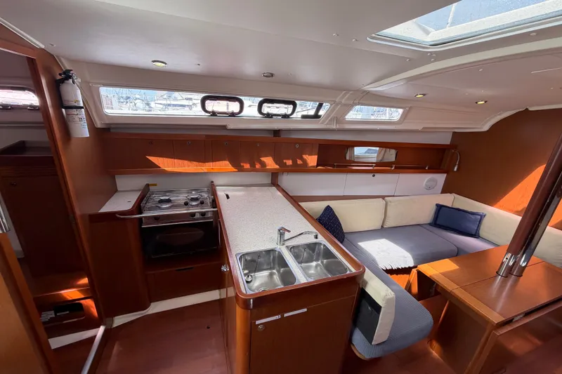 Slide: The Image of Interior of 2013 Beneteau Oceanis 370 yacht with kitchen and seating area. - 14