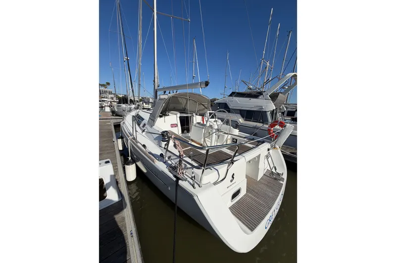 Slide: The Image of 2013 Beneteau Oceanis 370 sailboat docked at marina, clear blue sky background. - 3