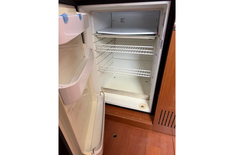 Slide: The Image of Open refrigerator inside 2013 Beneteau Oceanis 370 yacht, featuring wire shelves and door storage. - 31