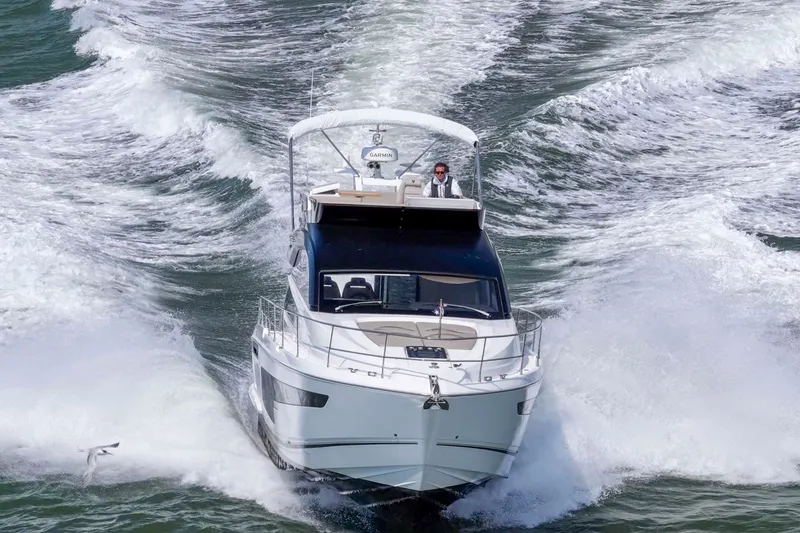 Slide: The Image of 2025 Fairline Squadron 50 yacht cruising swiftly on open water. - 16