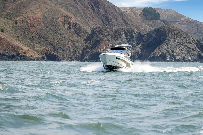 Slide: The Image of 2025 Fairline Squadron 50 yacht cruising near rocky coastline. - 18