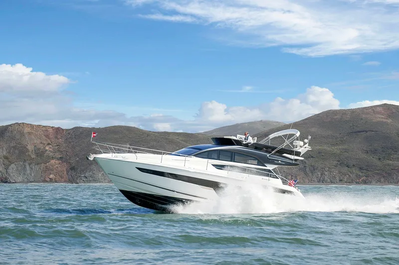 Slide: The Image of 2025 Fairline Squadron 50 yacht cruising on open water with scenic mountain backdrop. - 20