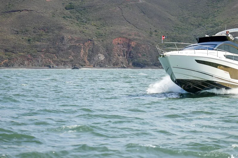 Slide: The Image of 2025 Fairline Squadron 50 yacht cruising near rocky coastline. - 19