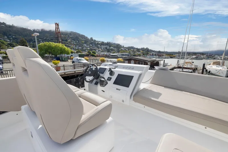 Slide: The Image of Flybridge of 2025 Fairline Squadron 50 yacht with modern helm and seating, docked in marina. - 93