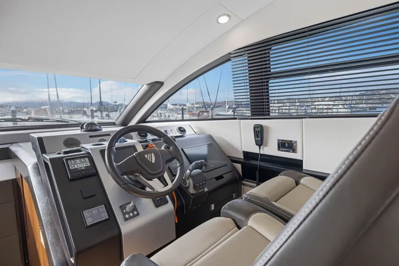 Slide: The Image of Interior cockpit of 2025 Fairline Squadron 50 yacht, featuring modern controls and luxurious seating. - 57