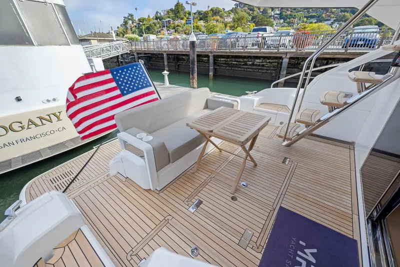 Slide: The Image of Luxury Fairline Squadron 50 yacht deck with seating, table, and American flag, 2025 model. - 90