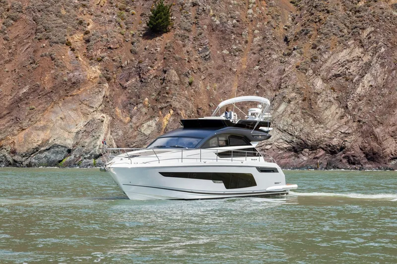 Slide: The Image of 2025 Fairline Squadron 50 yacht cruising near rocky coastline. - 38