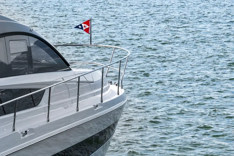 Slide: The Image of 2025 Fairline Squadron 50 yacht on water, featuring sleek design and nautical flag. - 48