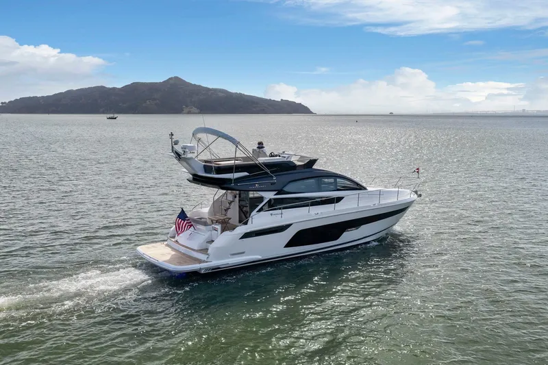 Slide: The Image of 2025 Fairline Squadron 50 yacht cruising on open water with scenic mountain backdrop. - 44