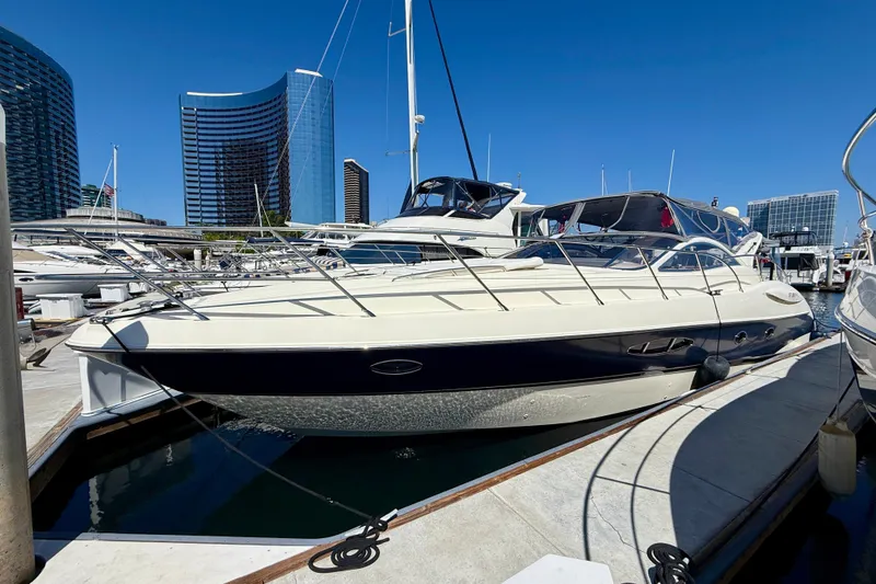 The Image of 2006 Azimut Atlantis 47 yacht docked in a marina with city skyline backdrop. - 0
