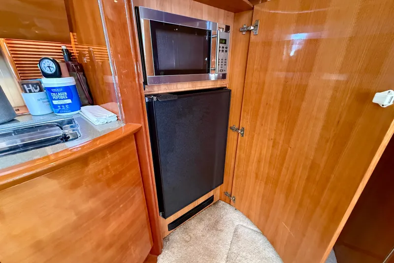 Slide: The Image of 2006 Azimut Atlantis 47 yacht interior with microwave and wooden cabinetry. - 24