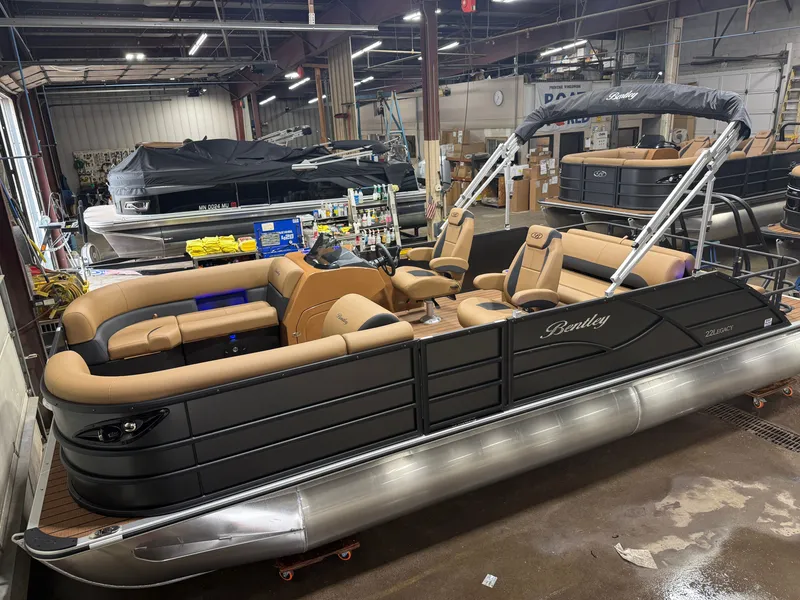 Slide: The Image of A 2027 Bentley Pontoons Legacy 220 Swingback with Honda 4-Stroke EFI in a warehouse setting. - 2