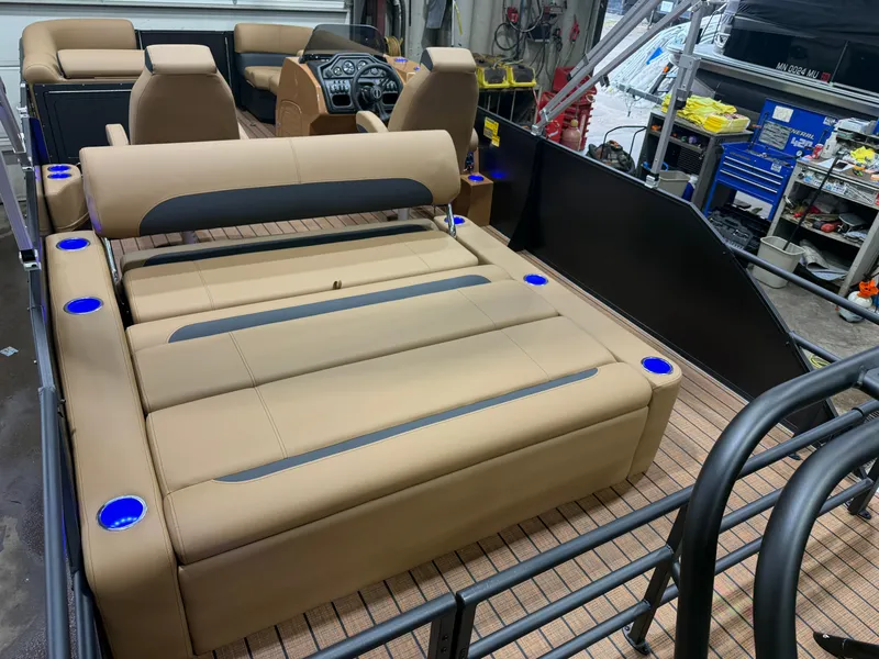 Slide: The Image of The image shows the interior of a Bentley Pontoons Legacy 220 Swingback with beige seating and blue cup holders. - 21
