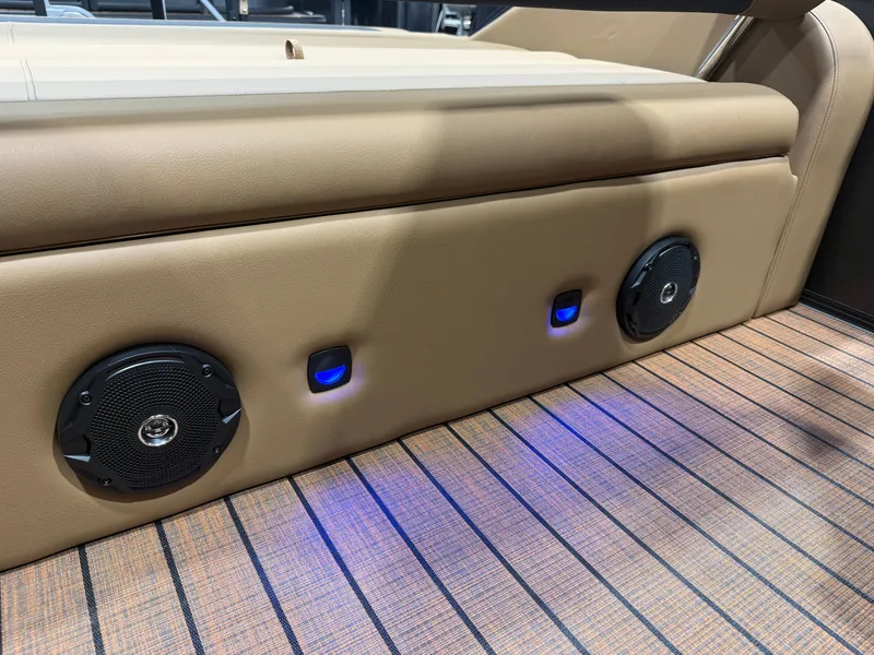 Slide: The Image of The Bentley Pontoons Legacy 220 Swingback features a cushioned bench with built-in speakers and blue lighting. - 33