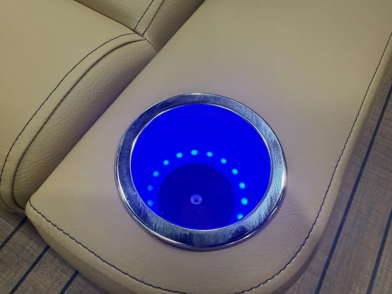 Slide: The Image of A blue illuminated cup holder is integrated into the beige upholstery of a boat. - 23