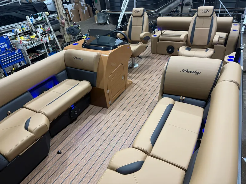 Slide: The Image of The image shows the interior of a Bentley Pontoons Legacy 220 Swingback. It features luxurious beige and black seating. - 31