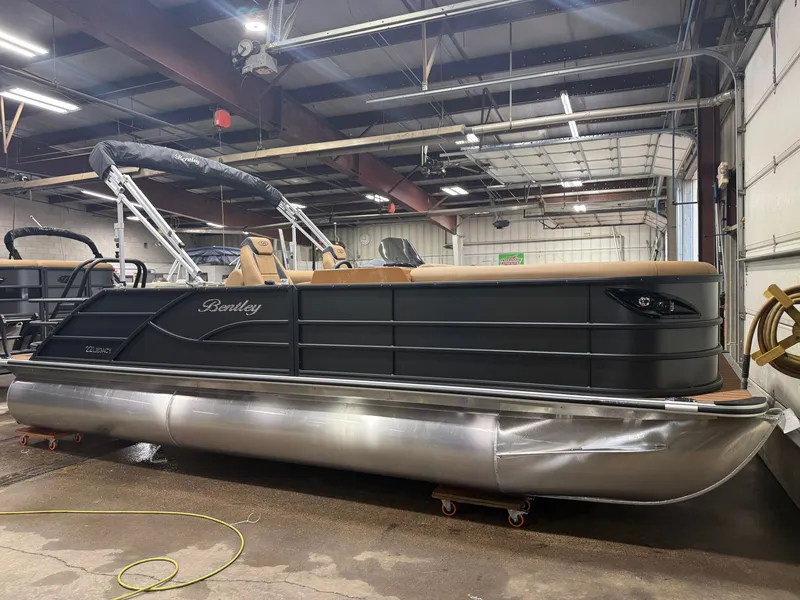 Slide: The Image of A 2027 Bentley Pontoons Legacy 220 Swingback in a warehouse. It features a sleek design with a Honda 4-Stroke EFI engine. - 46
