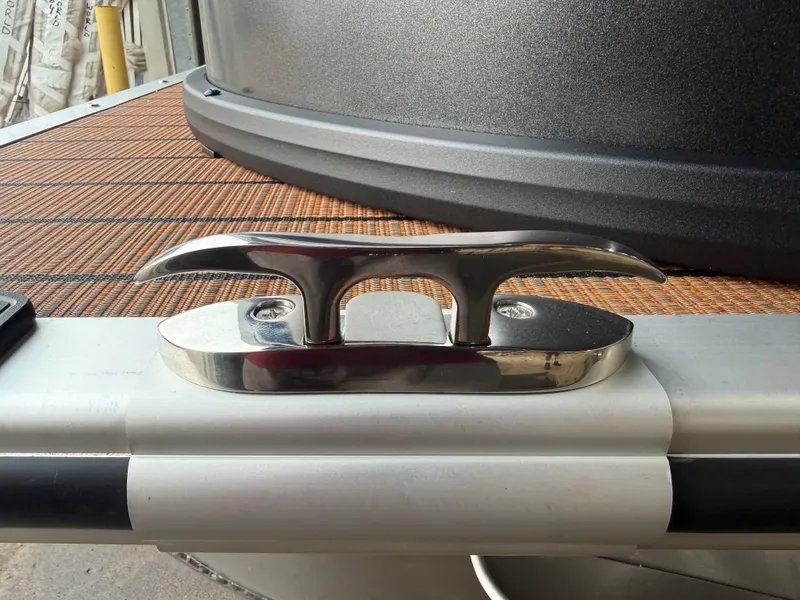 Slide: The Image of Close-up of a shiny metal cleat on a boat with a wooden deck. - 36