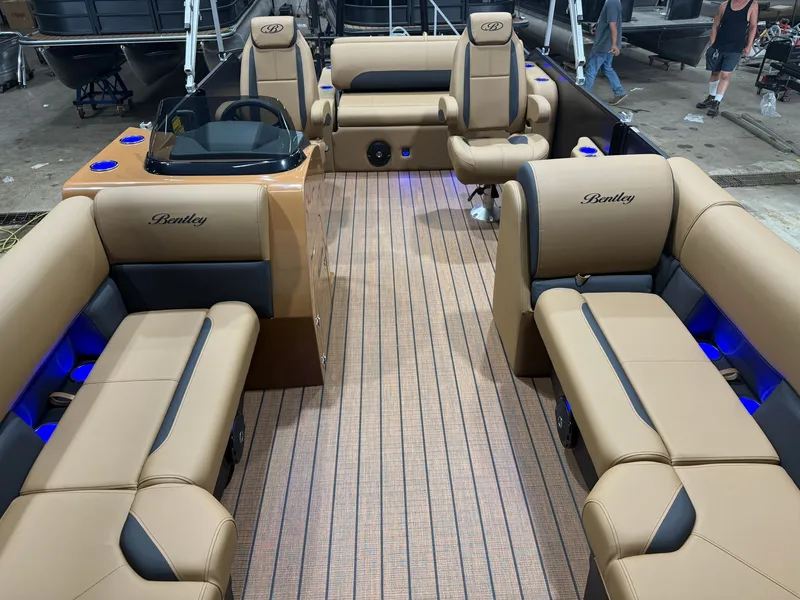 Slide: The Image of The image shows the interior of a Bentley Pontoons Legacy 220 Swingback with beige upholstery and blue lighting. - 6