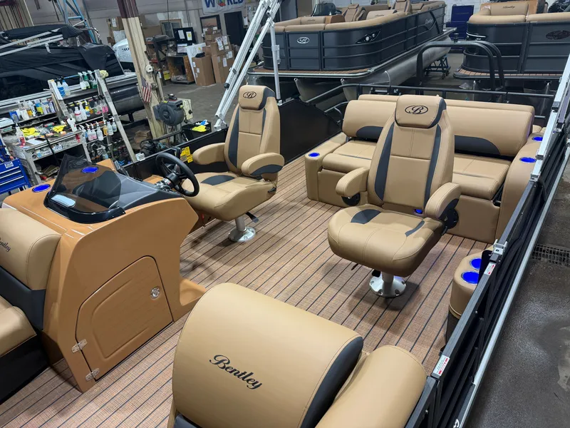 Slide: The Image of The image shows the interior of a Bentley Pontoons Legacy 220 Swingback with beige leather seats and a modern helm. - 4