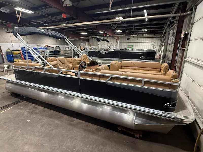 Slide: The Image of A modern pontoon boat with beige seating and a black canopy in a warehouse setting. - 40