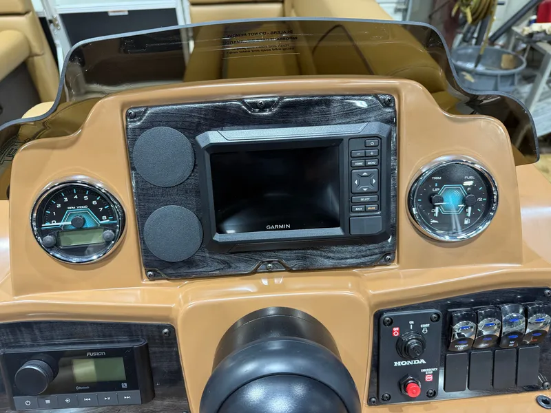 Slide: The Image of The dashboard of a boat featuring a speedometer, Garmin screen, and Honda controls. - 15