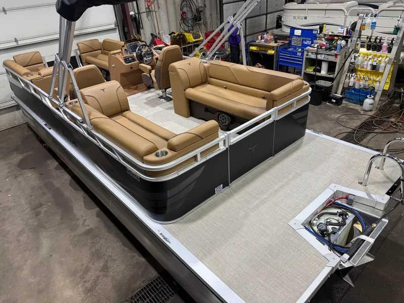 Slide: The Image of A modern pontoon boat with beige leather seating and a Honda 4-stroke engine in a workshop. - 41