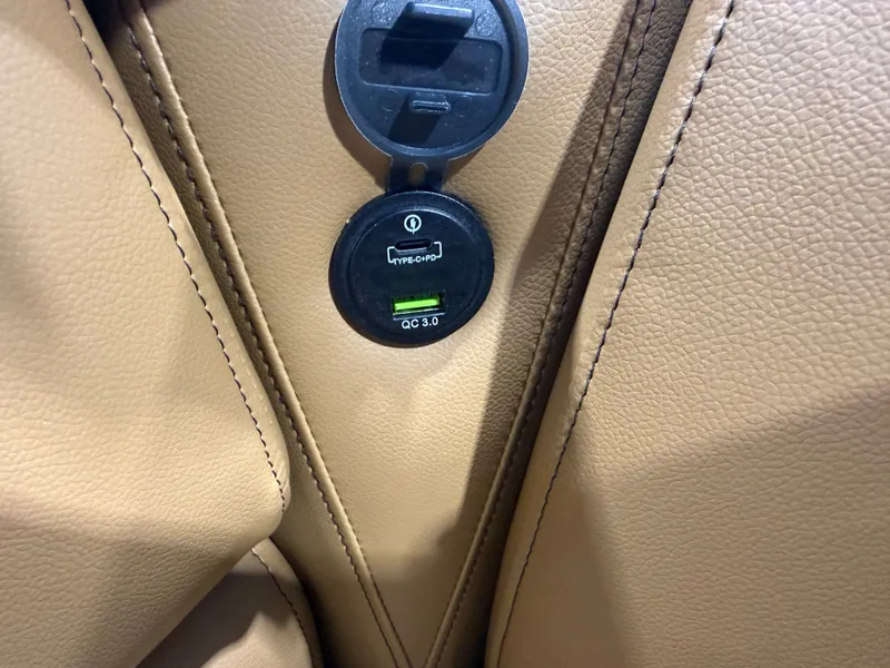 Slide: The Image of Close-up of a USB charging port in a beige leather seat. - 27