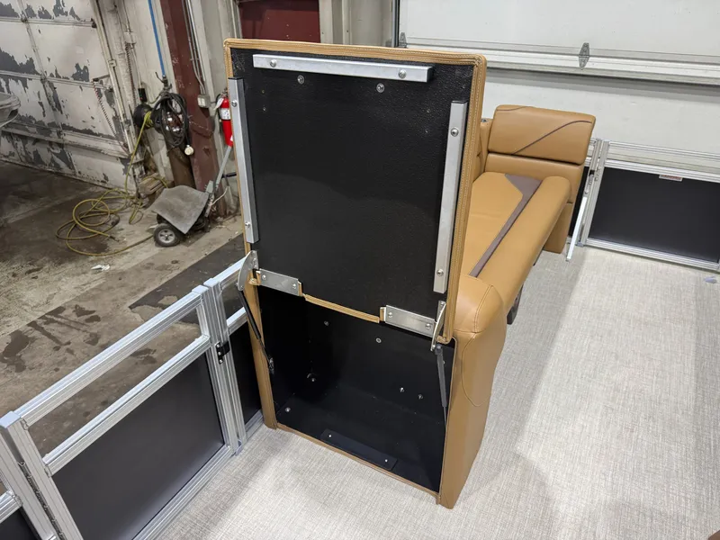 Slide: The Image of The image shows a boat interior with a seat flipped up, revealing storage underneath. The upholstery is brown. - 24